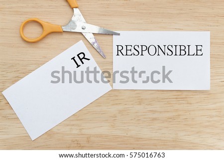 Scissor cut the paper to change the word IRRESPONSIBLE to RESPONSIBLE. Conceptual. Royalty-Free Stock Photo #575016763