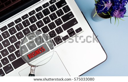 BUSINESS word on magnifier glass at keyboard. Communication in business networking concept