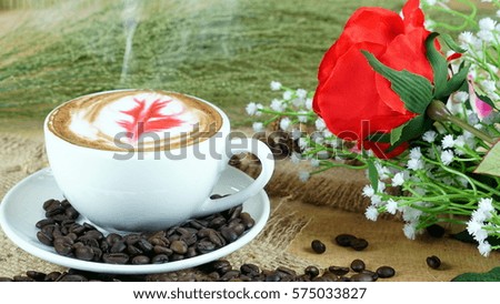 Coffee rose latte on a wood table with dark roasted coffee beans. Make the rose with milk to be in love on Valentine's day.