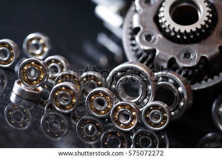 Machinery concept. Set of various gears and ball bearings on dark background Royalty-Free Stock Photo #575072272