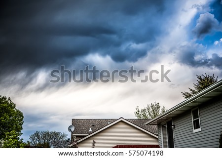 Thunderstorm clouds over suburban houses Royalty-Free Stock Photo #575074198