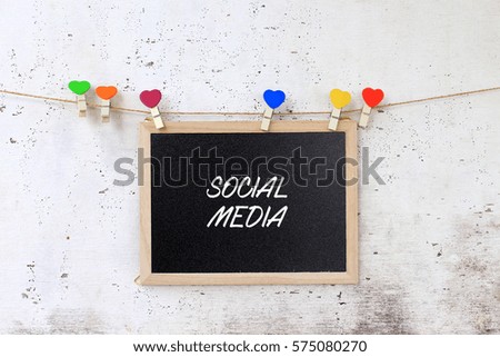 Social media - concept words on blackboard with wooden clamps on rustic wooden background.