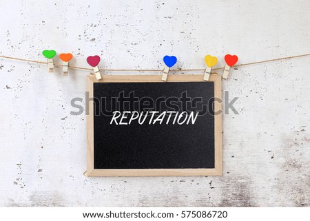 Reputation - concept words on blackboard with wooden clamps on rustic wooden background.