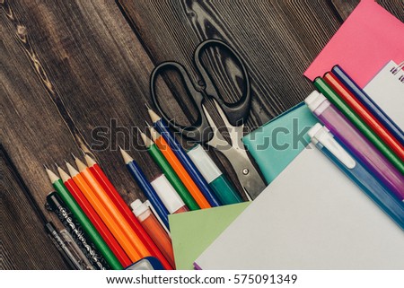 business card, notebook, sunglasses, pens, markers and scissors on the wooden background.