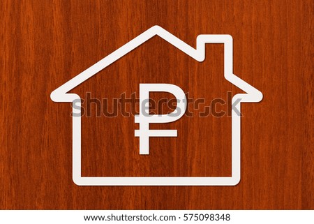 Paper house with ruble sign inside on wooden background. Business or finance concept. Abstract conceptual image.