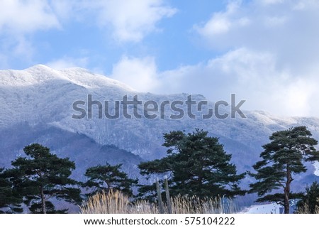 Beautiful snow landscape with mountains covered with snow and blue sky and white clouds above