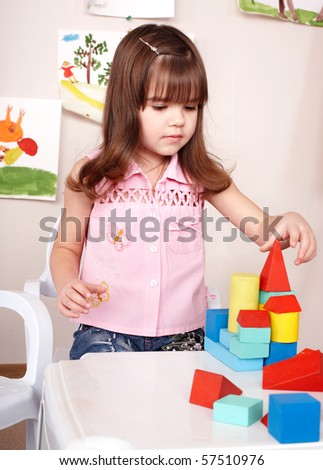 Little girl  playing with wood block  in  room. Preschool.