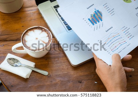 stack of folders and documents on office desk with coffee and laptop