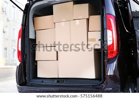 Office moving concept. Cartoon boxes in a car trunk
