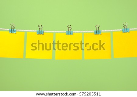 Empty yellow paper notes on the string over color background