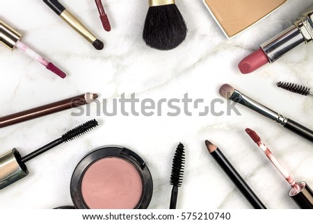 Makeup brushes, pencils, lipstick and other objects, forming a frame on a light background, with copy space. A horizontal template for a makeup artist's business card or flyer design