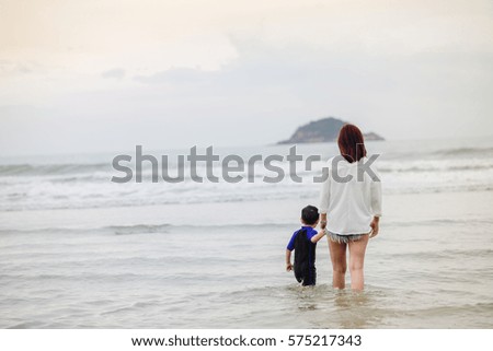 Stroll the beach as a family,Women, boys,Landscape sunset.