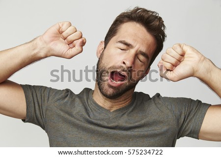 Guy yawning and stretching, studio Royalty-Free Stock Photo #575234722