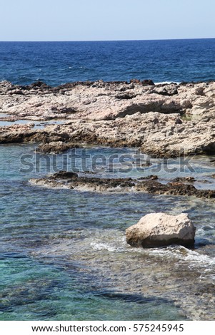 Sea waves crashing over rocks on wild stone beach in Balos lagune, Crete.Greece