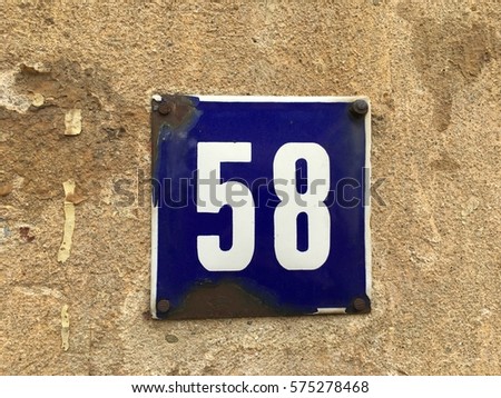 Vintage grunge square metal rusty plate of number of street address with number 58 closeup