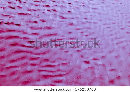 Red-blue and purple (violet) desert texture and background. Natural patterns on the sand. Dunes and Barchans