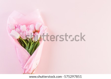 Bouquet of pink tulips wrappen in pink paper. Royalty-Free Stock Photo #575297851