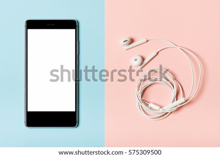 Smartphone on a blue background and headphones on a pink. Nice picture on the theme of modern technologies, communications, gadgets, etc. Flat fly