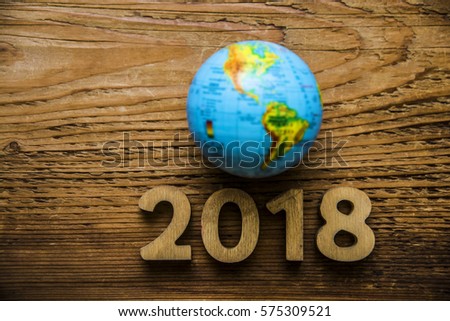 2018 happy new year. 2018 sign, symbol under globe map lie on wooden table. empty copy space. 
