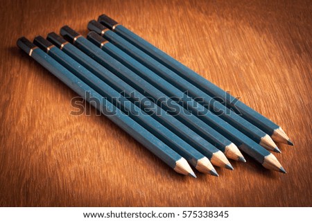Five pencils on the wooden table.