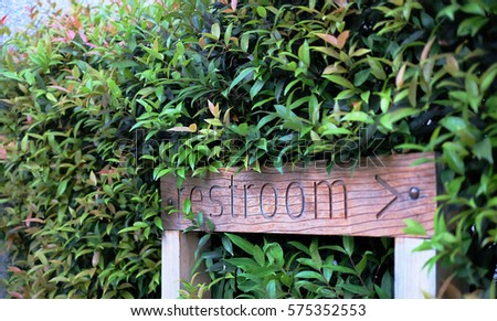 Wooden restroom sign in the garden