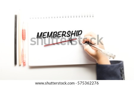 Hand writing MEMBERSHIP on notebook page, view from above