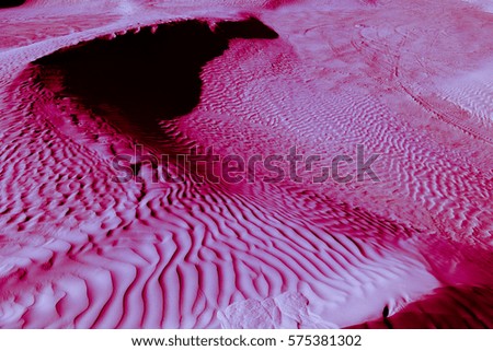 Red-blue and purple (violet) desert texture and background. Natural patterns on the sand. Dunes and Barchans