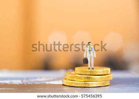 Miniature people businessman on coin