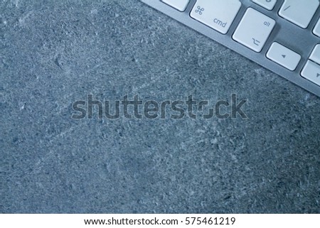 Computer keyboard on grey office table with copy space, top view modern style.
