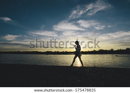 silhouette of a girl walking on a beach