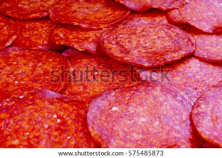 Red salami sliced meat from pig meat as background texture pattern.