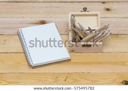 concept notebook, pencil in wooden barrels and flower on a wooden table