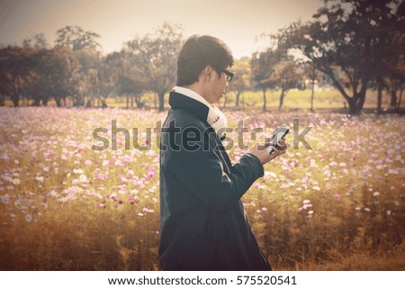 Beautiful autumn moment.Business man use smartphone  in the mountain garden park.Checking stock market on line.