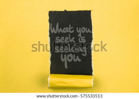 What you seek is seeking you. Words written under torn paper. Motivation concept text.
