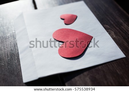 Dos cors royalty free images.White envelope with red heart shaped figures for 14 February.Write love letter for your beloved ones.Hand made Valentines letter for Saint Valentine Day celebration