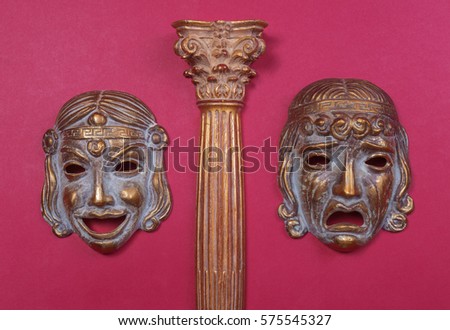 Masks of the Greek theater, representing joy and sadness, between a column of the same style Royalty-Free Stock Photo #575545327