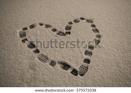 Cold Hearted: A heart made in the snow by boot prints.