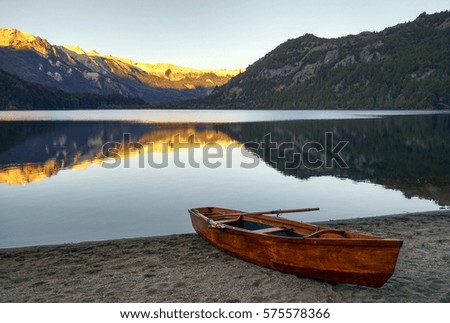 Photo of a small wooden rowing boat on the lake’s shore