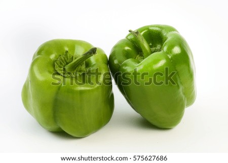 Two green bell peppers isolated on a plain white background