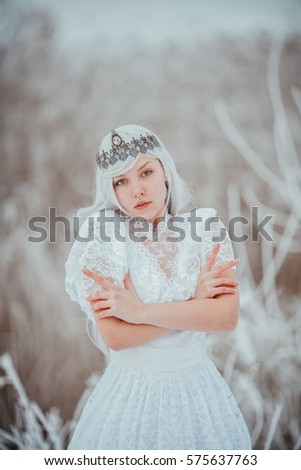 White fairytale princess in frozen world. Vintage wedding dress. Winter fantasy. 