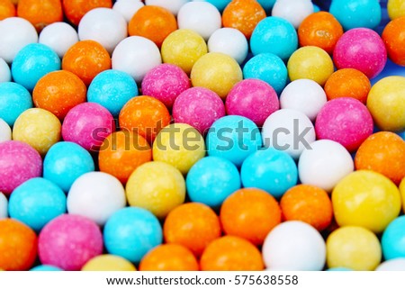 Shiny sugar coated round chocolate balls as background. Candy bonbons multicolored texture. Round candies sweets pattern concept. Food photo studio photography. Candy background.