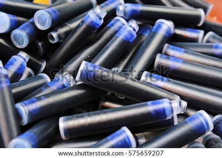 
  Pen ink Cartridge. Close up of the nib of a fountain pen ink cartridges. Inks as background. Texture photo studio photography