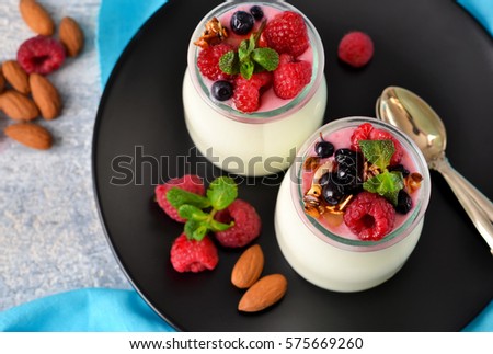 Vanilla yogurt with berries on a concrete background.