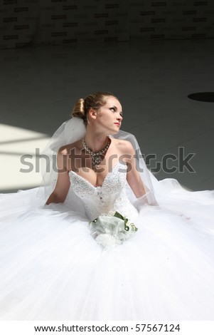 The beautiful bride in wedding dress sits on floor Royalty-Free Stock Photo #57567124