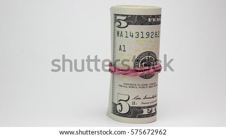 Bunch of dollars on the stack of dollars with red gum elastic band
