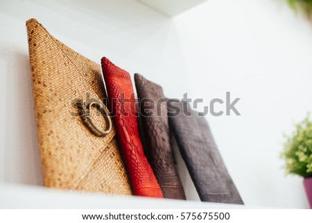 clutch bags of different colors on the shelf in the store