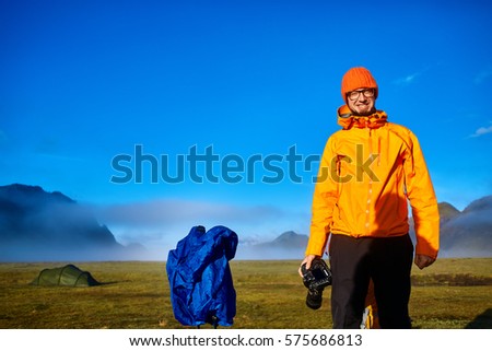 man hiker photographer taking picture on the mountain lake background in Iceland