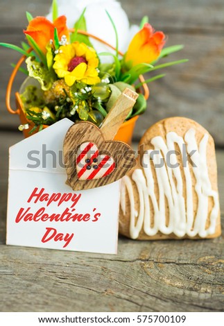 Heart shaped cookies and chocolate candies (big and small as couple), cup of coffee, bouquet of flowers decoration. sunny morning. Romantic breakfast or Valentine's Day Breakfast. Toned image
