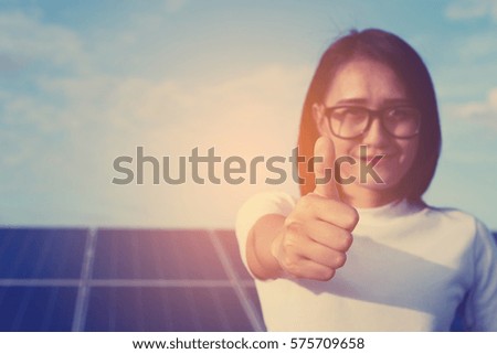 businesswomen working on checking equipment at solar power plant with tablet checklist; woman working on outdoor and showing thumbs up
