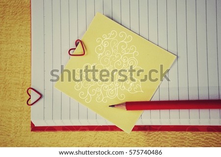 Note paper with sticker and a paper clip in the shape of a heart: the concept of Valentine's Day - February 14